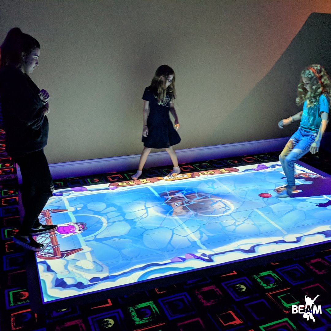 Children playing an interactive projection game on the floor